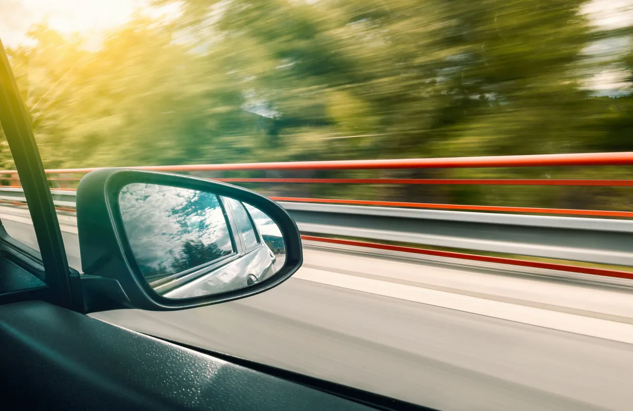 Wing mirror view from a moving car on a motorway
